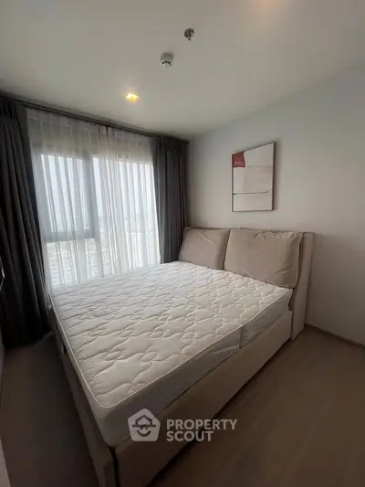 Cozy bedroom with large window and modern decor in a stylish apartment.