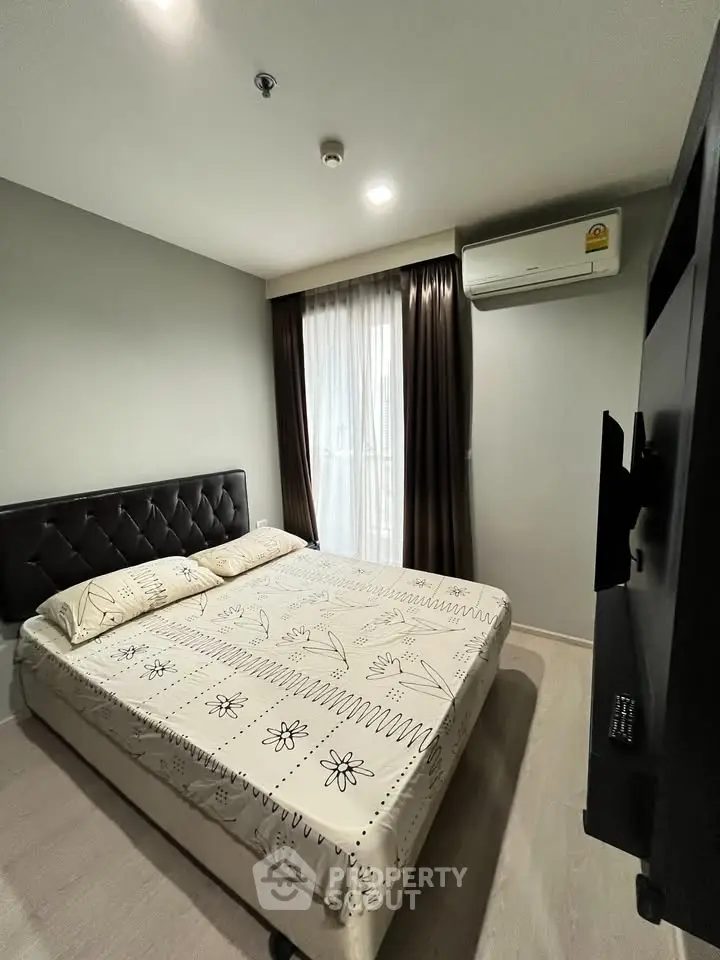 Cozy bedroom with modern decor and natural light in a stylish apartment.