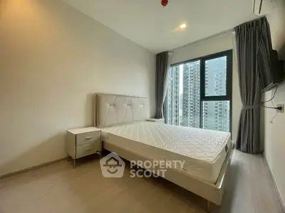 Modern bedroom with large window and city view in high-rise apartment