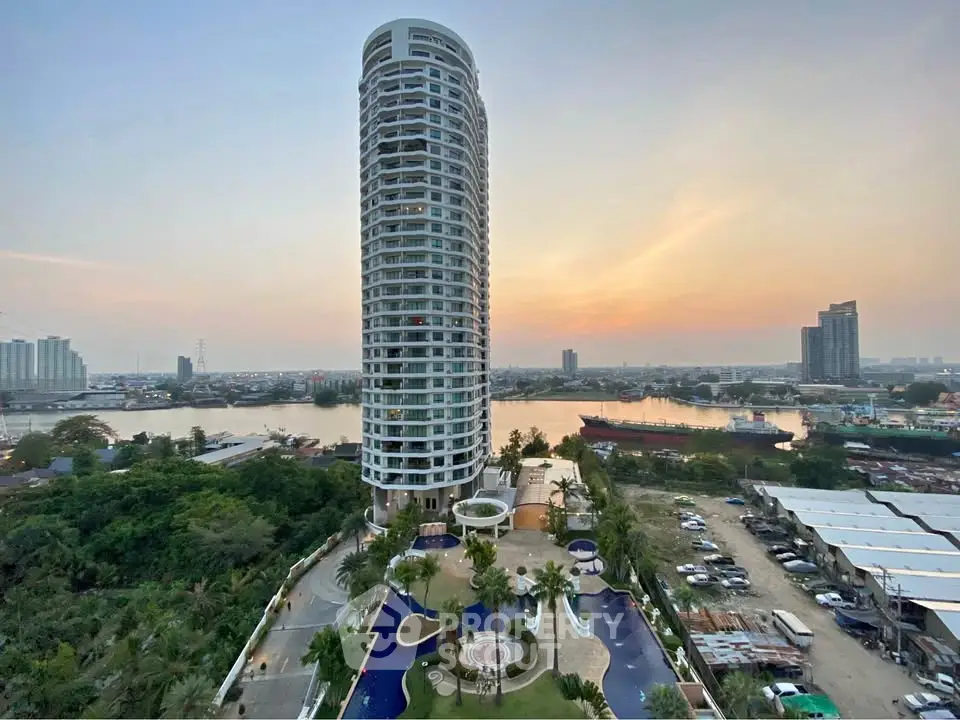 Stunning high-rise building with river view and luxurious pool area at sunset.