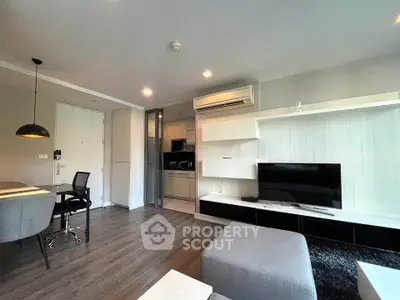 Modern living room with sleek furniture and open kitchen layout in a stylish apartment.
