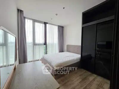 Spacious bedroom with large windows and modern furnishings