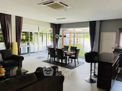 Spacious modern living and dining area with large windows and stylish decor.