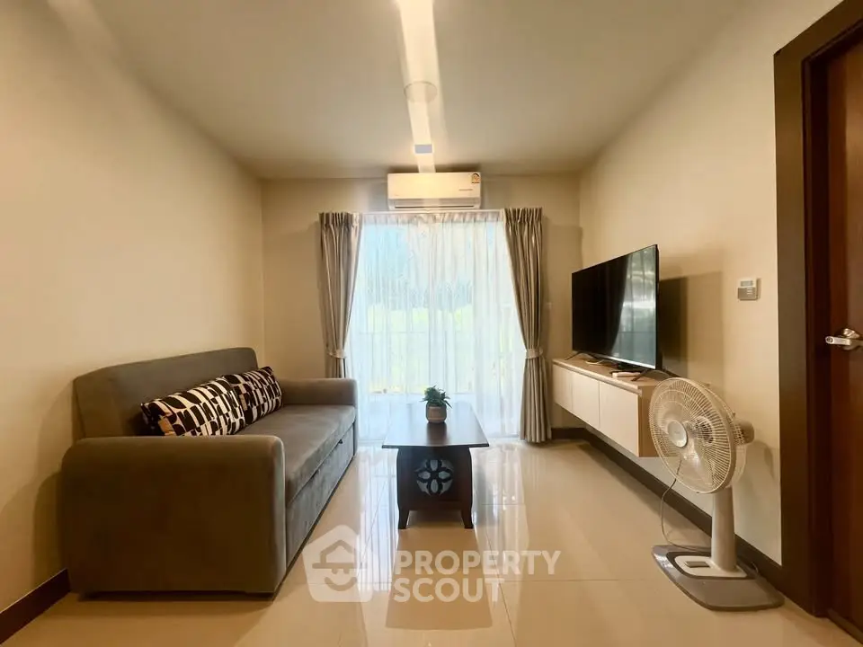 Modern living room with sleek furniture and natural light, perfect for relaxation and entertainment.