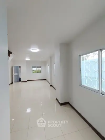 Spacious and bright living area with large windows and tiled flooring in modern home.