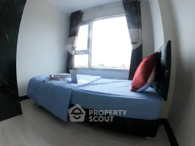 Cozy bedroom with large window and modern decor, perfect for relaxation and comfort.