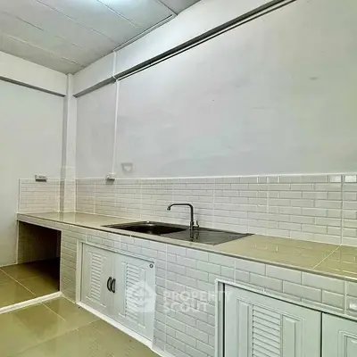 Modern kitchen with sleek white cabinetry and tiled backsplash