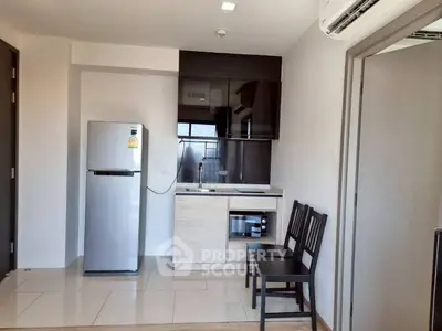 Modern compact kitchen with sleek appliances and dining area in a stylish apartment.