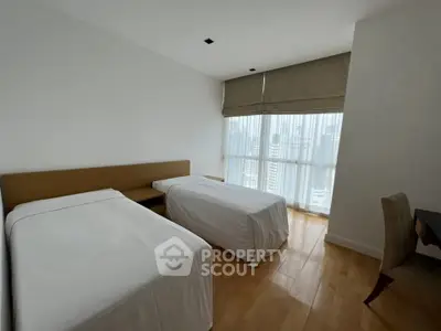 Spacious bedroom with twin beds and city view, perfect for urban living.