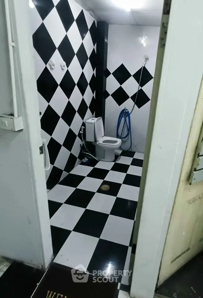 Modern bathroom with black and white checkered tiles and contemporary fixtures.