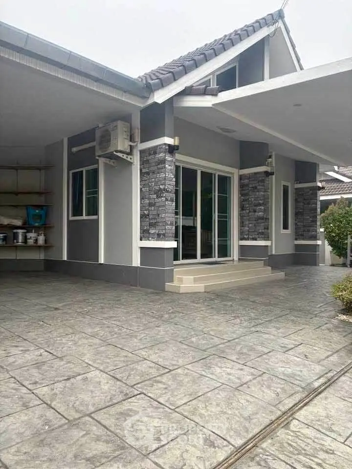 Modern single-story home with stylish stone accents and spacious driveway.