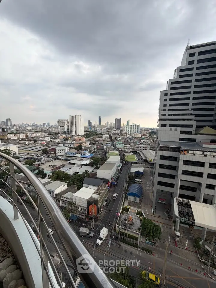 Stunning cityscape view from a high-rise balcony showcasing urban skyline and bustling streets below.