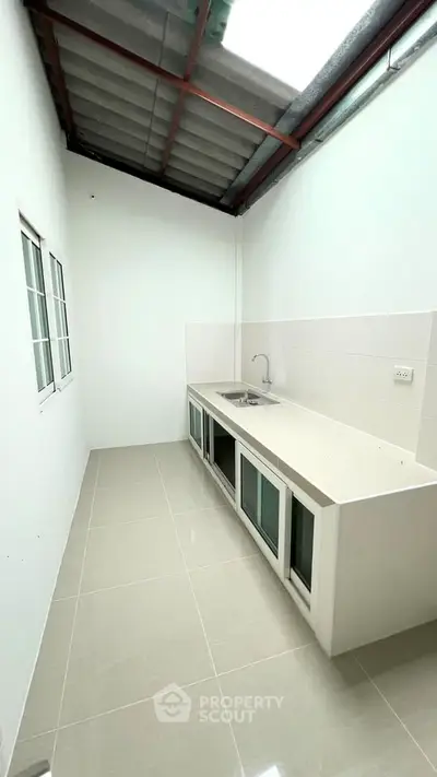 Spacious kitchen with sleek countertops and modern cabinetry in a bright, airy setting.
