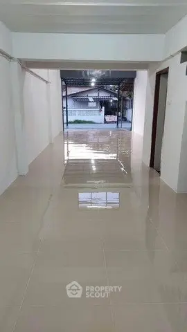 Spacious tiled hallway with natural light and open layout, ideal for versatile use.