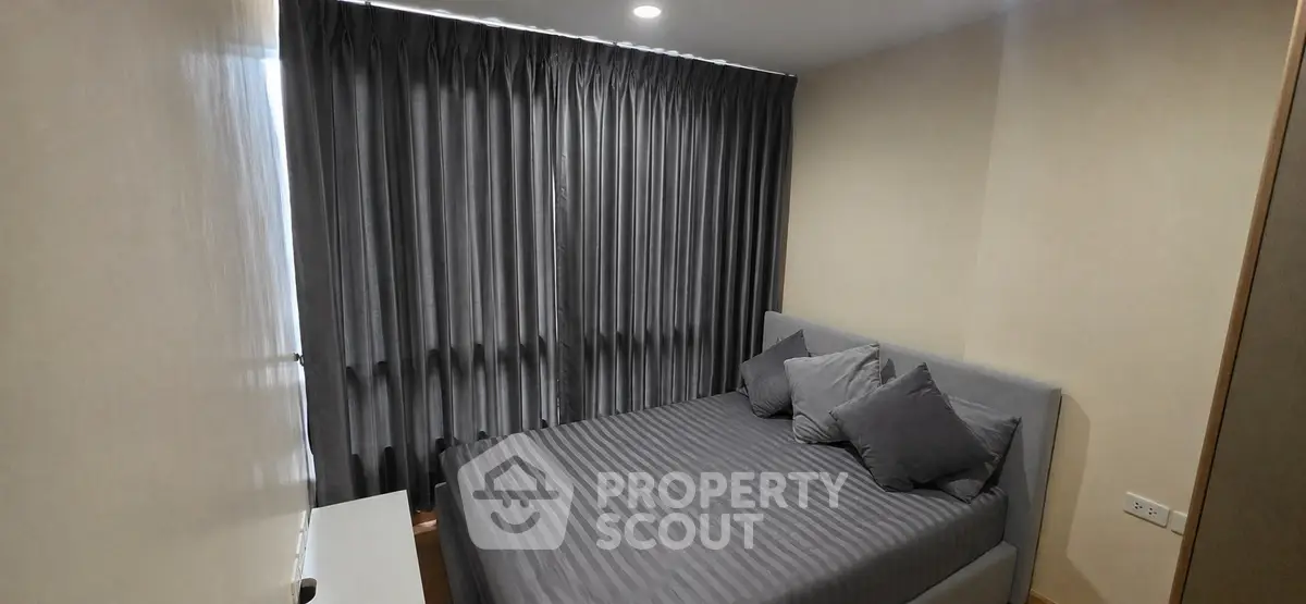 Cozy bedroom with modern gray decor and ample natural light