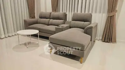 Modern living room with stylish gray sofa and elegant curtains