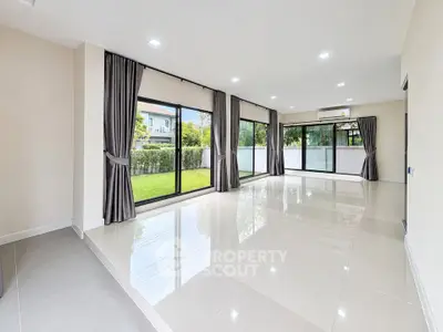 Spacious modern living room with large windows and garden view