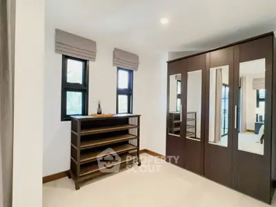 Spacious bedroom with mirrored wardrobe and natural light