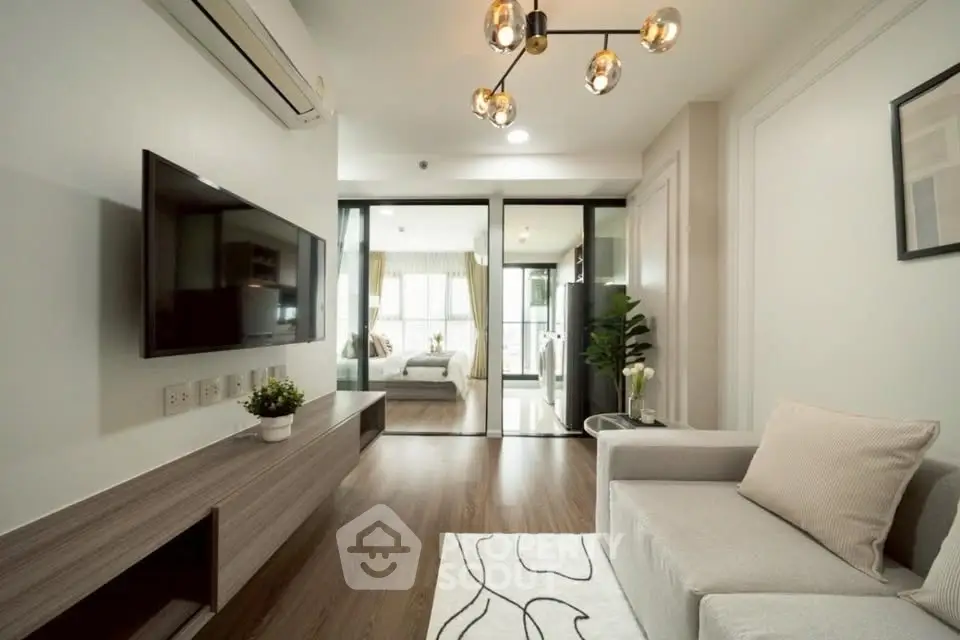 Modern living room with sleek design and view into a stylish bedroom, featuring elegant lighting and contemporary decor.