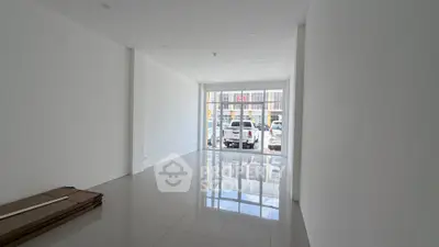 Spacious empty room with large windows and glossy tiled floor, ideal for customization.