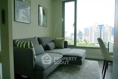 Modern living room with city view, featuring a stylish grey sofa and contemporary decor.