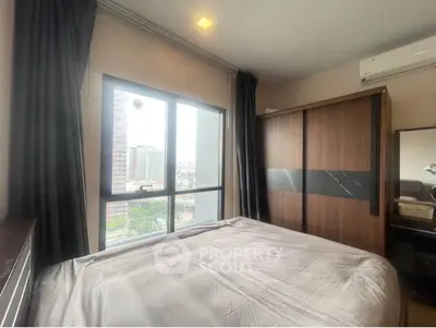 Modern bedroom with large window and city view, featuring sleek wardrobe and air conditioning.