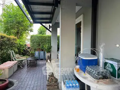 Charming outdoor patio with lush greenery and seating area, perfect for relaxation and entertaining.