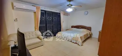 Spacious bedroom with cozy seating and elegant decor