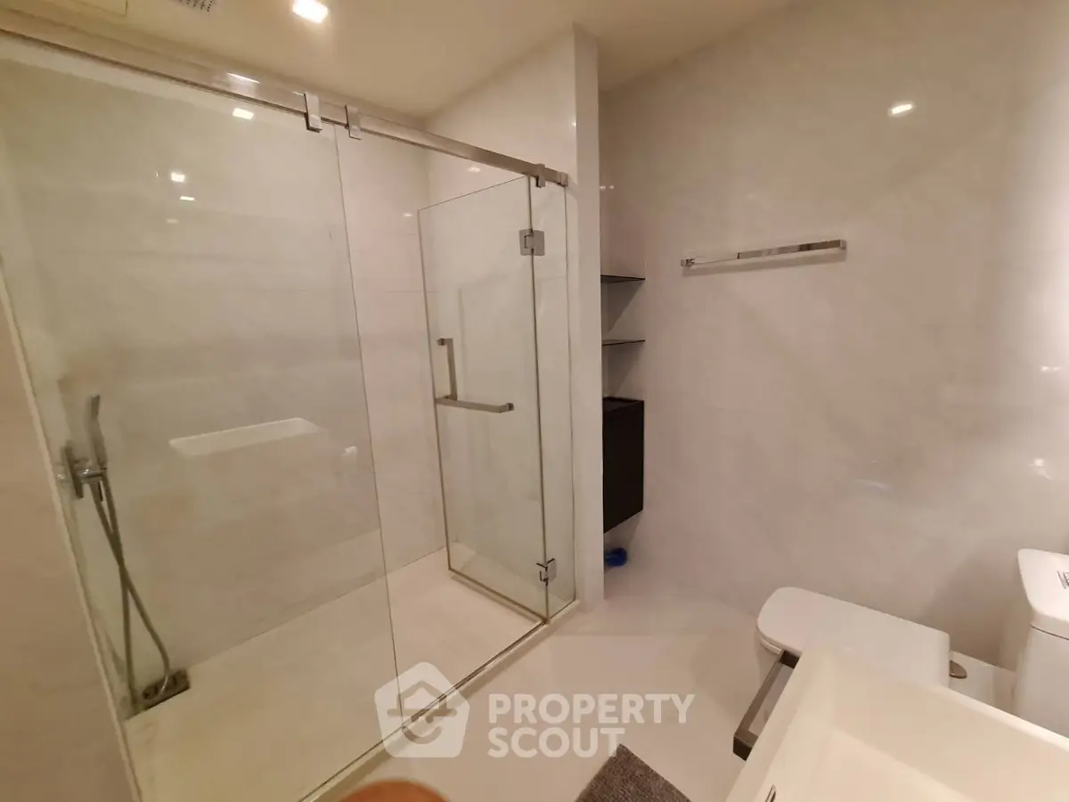 Modern bathroom with glass shower enclosure and sleek fixtures