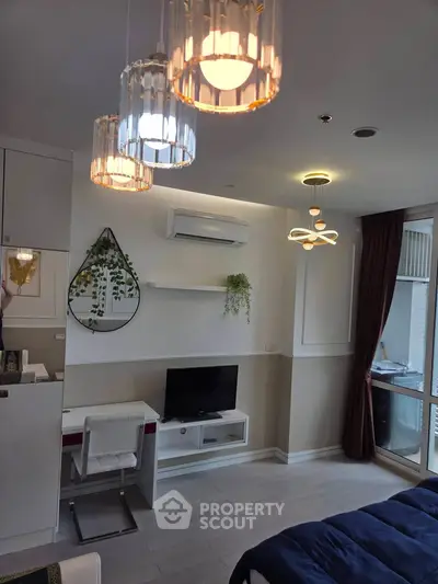 Modern living room with stylish lighting and air conditioning, featuring a cozy workspace and TV area.