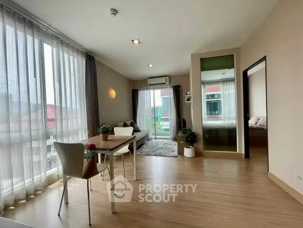 Spacious modern living room with large windows and stylish decor in a contemporary apartment.