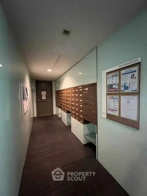 Modern apartment building hallway with mailboxes and information board