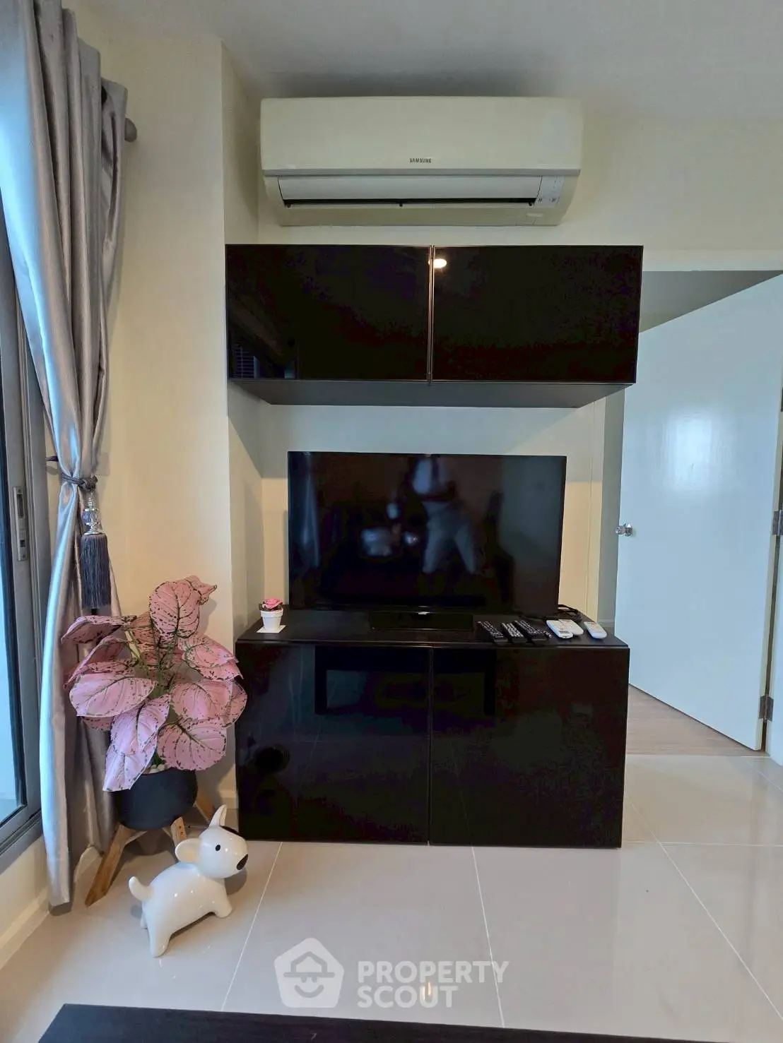 Modern living room with sleek black entertainment unit and air conditioning