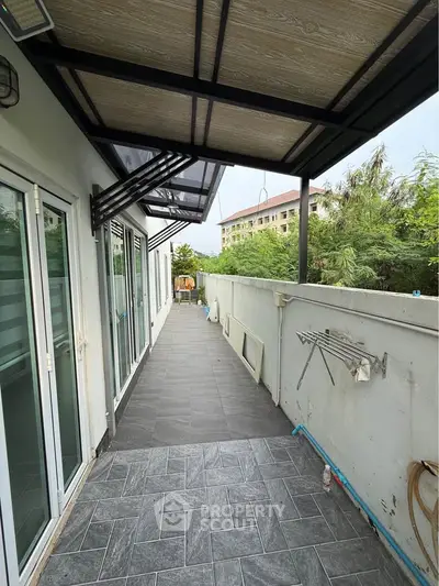 Spacious balcony with modern tiles and partial roof cover, ideal for outdoor relaxation.