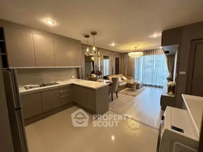 Modern open-layout kitchen and living room with elegant lighting and neutral tones.