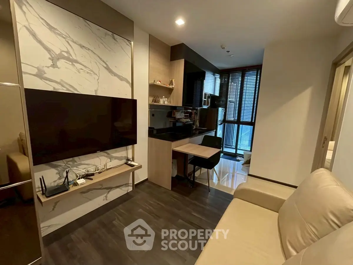 Modern living room with sleek design and open kitchen layout in a stylish apartment.