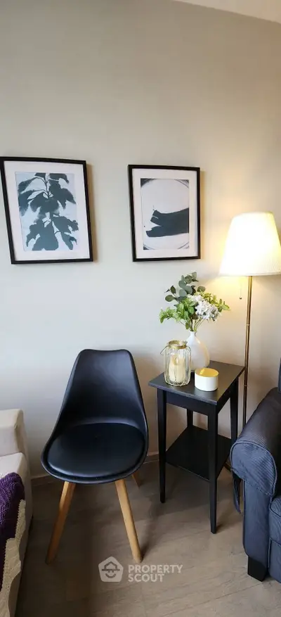 Stylish living room corner with modern chair, side table, and framed art.