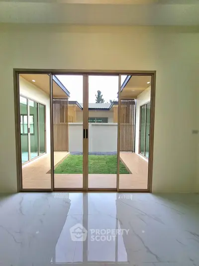 Modern interior with sliding glass doors opening to a private courtyard garden.