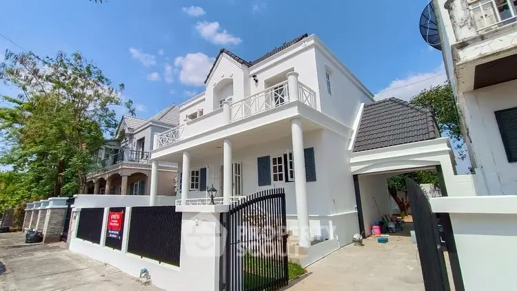 Elegant white two-story house with balcony and gated entrance