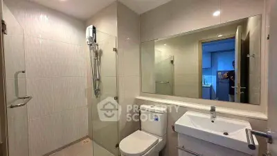 Modern bathroom with glass shower and sleek fixtures in contemporary apartment.