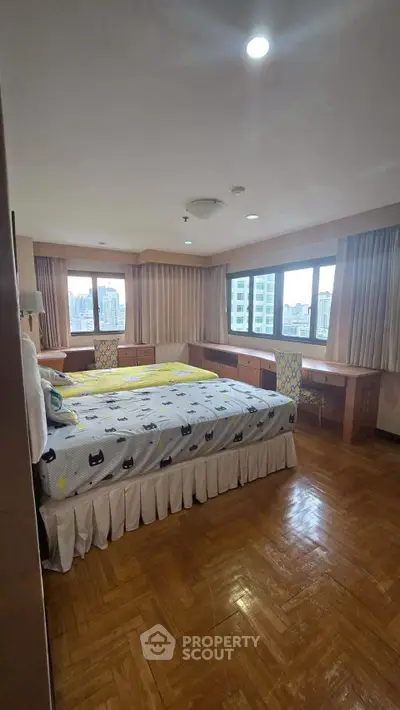 Spacious bedroom with city view and wooden flooring in modern apartment