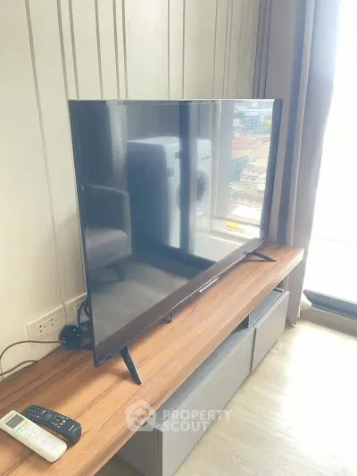 Modern living room with sleek TV and city view, perfect for urban lifestyle.