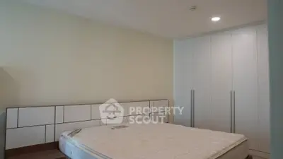 Spacious bedroom with modern wardrobe and comfortable bed in a stylish apartment.