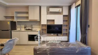 Modern living room with sleek furniture and built-in storage, featuring a compact kitchen area.