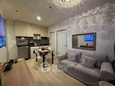 Modern living room with cozy sofa, dining area, and compact kitchen in open layout.