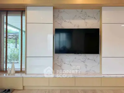 Modern living room with sleek TV setup and marble accents
