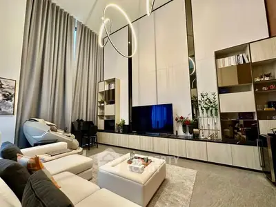 Luxurious modern living room with high ceilings, elegant lighting, and stylish decor.