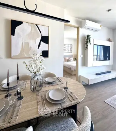 Modern dining area with elegant table setting and view into cozy bedroom