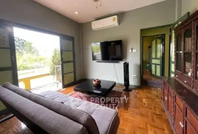 Charming living room with modern decor and garden view, featuring sleek furniture and parquet flooring.