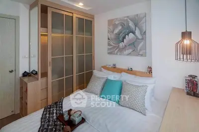 Cozy bedroom with modern decor and ample storage in a stylish apartment.